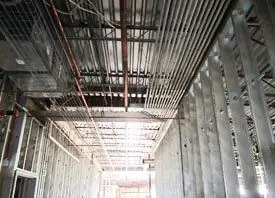 Overhead conduit and cable tray runs across a finished commercial ceiling