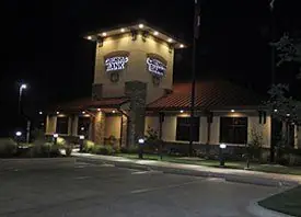 Restaurant exterior at night lit by its own canopy lighting